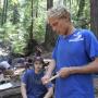 Harrison demonstrates carving technique for a student. Members of the class learn to carve a spindle and fire board--the tools for making a friction fire.