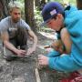Assistant Adventure Out instructor Mark Maitland, left, looks on as a student assembles a fire bow.
