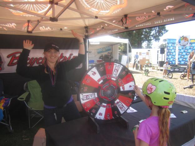 Alyse Weyman spins the Giant Wheel of goodies at the Bicycle Trip tent.