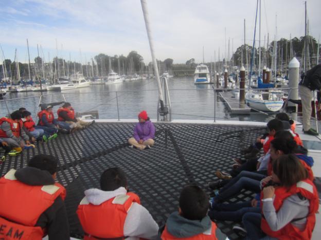 Celia Lara of O'Neill Sea Odyssey gives fifth graders from Watsonville's Ann Soldo Elementary School  an orientation on the O'Neill Catamaran's mesh deck.